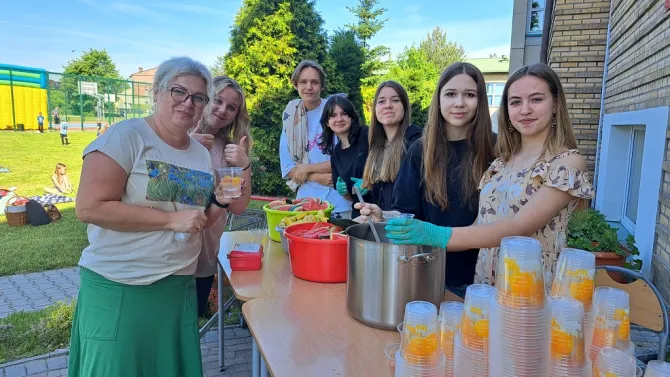 Na zdjęciu uczestnicy pikniku wraz z wychowawcami z okazji Dnia Dziecka zorganizowanego w Szkole Podstawowej Nr 1 im. Jana Pawła II w Czerwionce-Leszczynach (stoisko między innymi z owocami i napojami)