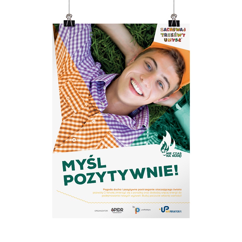 Plakat akcji "Myśl pozytywnie" przedstawia uśmiechniętego chłopaka leżącego na trawie. Na plakacie znajduje się krótka informacja o roli pozytywnego postrzegania otaczającego świata.